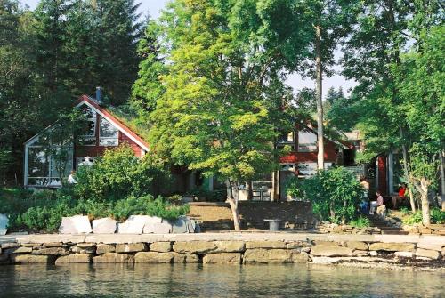 a house sitting on the shore of a body of water at Hardanger Feriesenter Nesvika in Norheimsund