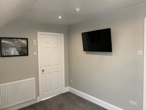 a room with a flat screen tv on a wall at The Victoria guest house in Mablethorpe