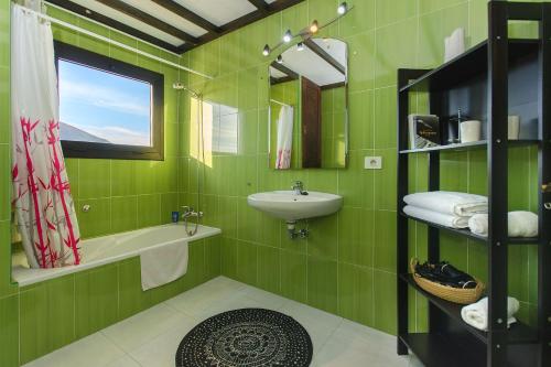 a green bathroom with a sink and a mirror at Casa Clara 3 in Conil