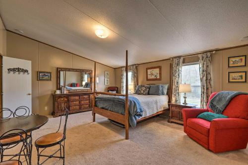 1 dormitorio con 1 cama y 1 silla roja en Lakeside Escape with Dock - Fish, Hike and Explore!, en Waverly Hall