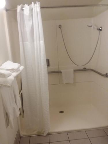 a bathroom with a shower with a white shower curtain at Comfort Inn Somerset in Somerset