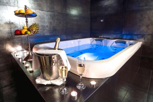 una vasca da bagno con bicchieri da vino e una bottiglia di champagne di Hotel & Restoran Dvorac Gjalski a Zabok