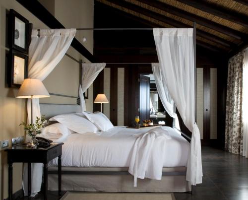 a bedroom with a white bed with a canopy at Asia Gardens Hotel & Thai Spa, a Royal Hideaway Hotel in Finestrat