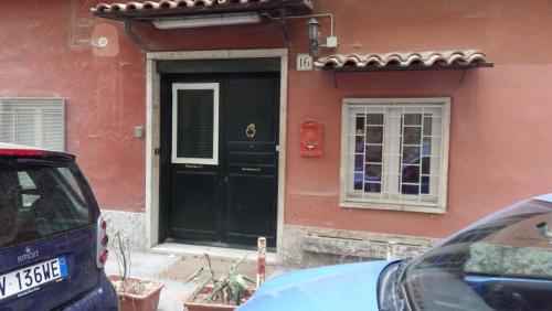 ローマにあるLa Casetta di Paolaの前方に車を停めた建物の黒い扉