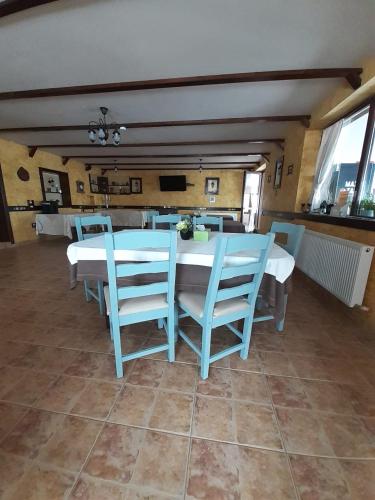 a dining room with a table and blue chairs at Pensiunea Tabacaru in Peştera