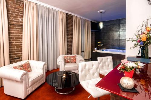 a living room with white chairs and a table at Hotel & Restoran Dvorac Gjalski in Zabok