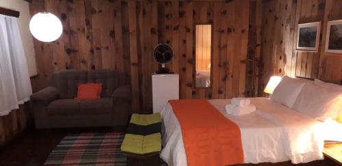 a bedroom with a bed and a chair and a couch at Hotel Refazenda in Visconde De Maua