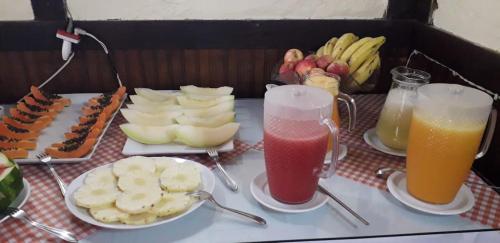 a table topped with plates of fruit and juice at Hotel Refazenda in Visconde De Maua