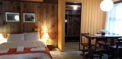 a bedroom with a bed and a desk and a table at Hotel Refazenda in Visconde De Maua