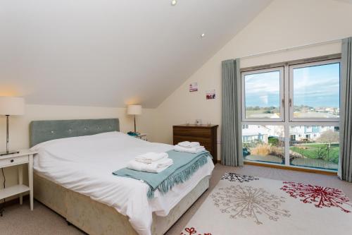 a bedroom with a bed and a large window at 4 Salterns - Freshwater in Freshwater