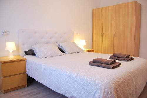 Apartamento en Cambrils Puerto,con Parking في كامبريلس: غرفة نوم بسرير كبير عليها منشفتين