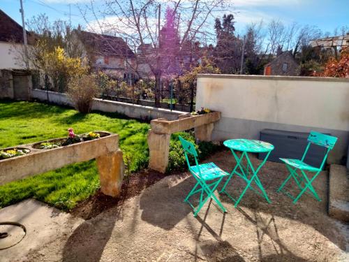 two blue chairs and a table in a yard at Les ammonites gîte de charme en Bourgogne in Guillon