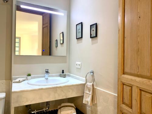 ein Badezimmer mit einem Waschbecken und einem großen Spiegel in der Unterkunft Homely Málaga Pozos Dulces 27 centro histórico in Málaga