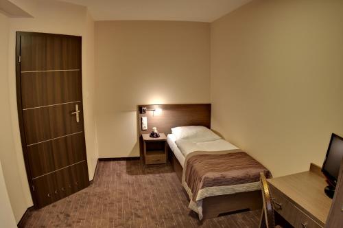 a hotel room with a bed and a television at Villa Martini in Międzyzdroje