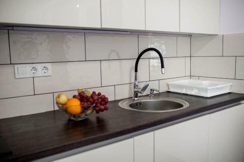 a kitchen counter with a sink and a bowl of fruit at Apartments Dora Sveti Martin na Muri in Sveti Martin na Muri
