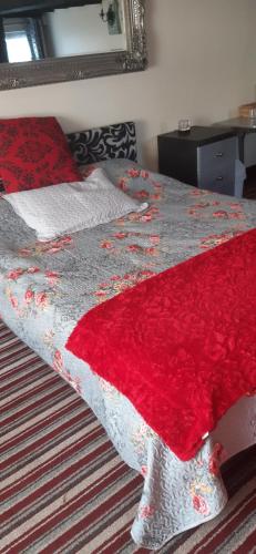 a bed with a red and white blanket on it at The Saracens Head Old Lounge in Skegness