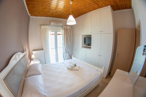 a bedroom with a large white bed and a window at Marabu Seaview Apartments in Nótos