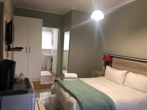 a small bedroom with a bed and a television at Ndzuti Guest House in Witbank