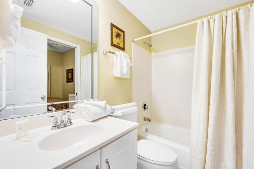 a bathroom with a sink and a toilet and a mirror at Sterling Sands 708 Destin (Condo) in Destin