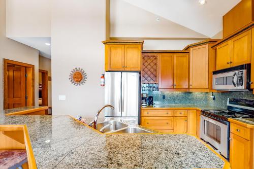 a kitchen with wooden cabinets and a sink at Spyglass 4C in Big White