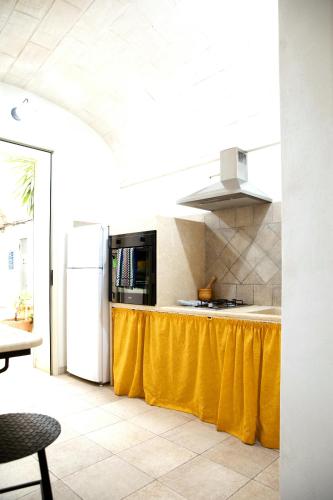 a kitchen with a white refrigerator and a yellow table at Fardella 250 in Trapani
