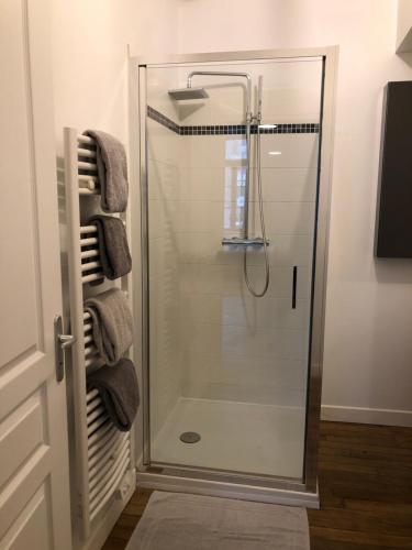 a glass shower in a bathroom with towels at Som-home in Péronne