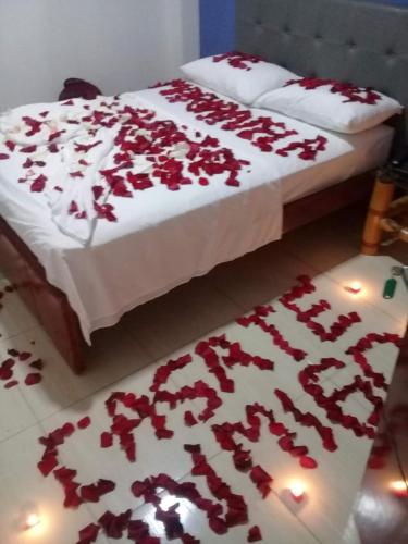 a bedroom with a bed covered in red rose petals at Hotel la Embajada Antioqueña in Cúcuta