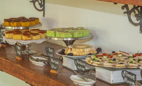 a buffet with many different types of cakes and pies at Pousada Novo Prado in Prado