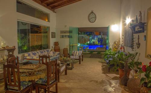 a living room with chairs and a clock on the wall at Pousada Novo Prado in Prado
