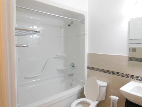 a bathroom with a shower and a toilet and a sink at NU Hotel Toronto Airport in Mississauga