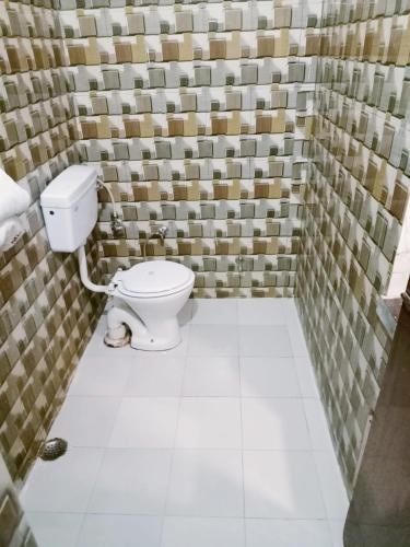 a bathroom with a toilet in a room with tiles at Hotel marwari niwas in Haridwār