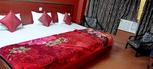 a bedroom with a bed with a red blanket at Hotel marwari niwas in Haridwār