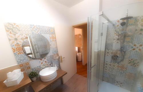 La salle de bains est pourvue de toilettes et d'une douche en verre. dans l'établissement La Casina del Porto, à Fano