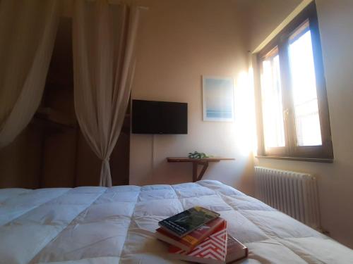 um quarto com uma cama com dois livros em La Casina del Porto em Fano