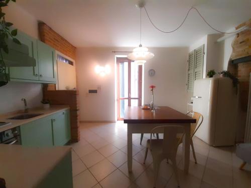 uma cozinha com uma mesa e um frigorífico em La Casina del Porto em Fano