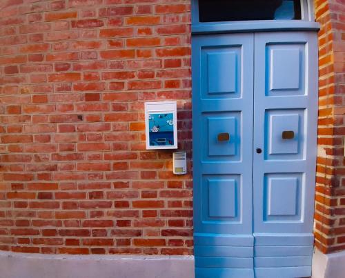 een blauwe deur aan de zijkant van een bakstenen gebouw bij La Casina del Porto in Fano
