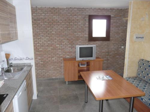 a kitchen with a table and a tv on a counter at Aranjuez Camping & Bungalows in Aranjuez
