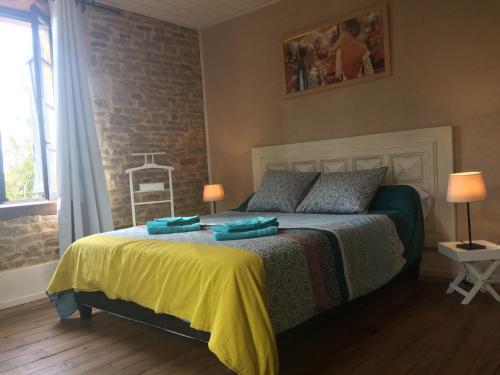 a bedroom with a bed and a brick wall at La Dolce Vita des Hautes Côtes in Magny-lès-Villers