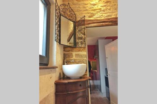 a bathroom with a bowl sink on a wooden dresser at La Dolce Vita des Hautes Côtes in Magny-lès-Villers