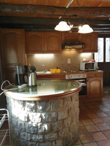 a kitchen with a stone island in the middle of it at Gîte Le Courtil in Bouillon