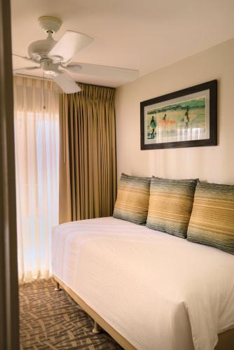 a bedroom with a bed and a ceiling fan at Paniolo Greens Resort in Waikoloa
