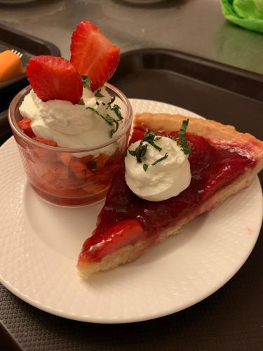 a white plate with a piece of pie and a bowl of fruit at FH Confort Hotel Orléans Co'met in Orléans
