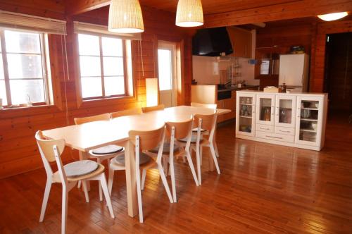 een keuken met een tafel en stoelen in een kamer bij Niseko FOREST VILLA in Niseko
