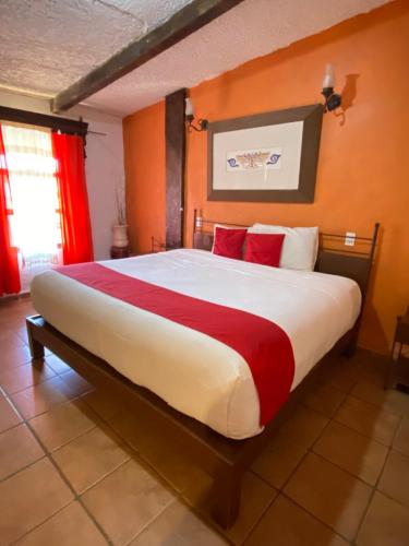 a bedroom with a large bed with red pillows at Hotel De Cervantes in San Sebastián