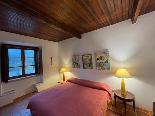 a bedroom with a bed and two lamps and a window at Monte dos Pensamentos - Turismo Rural in Estremoz