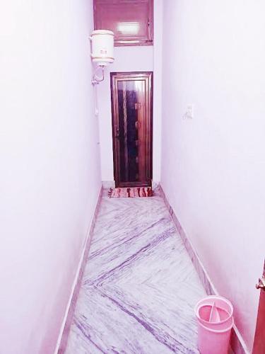 an empty hallway with a door and a bucket at Aaranya Retreat by Agrawal s in Haridwār