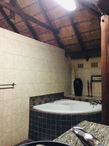 un bagno con una grande vasca in una stanza di Mopani Guest House a Giyani