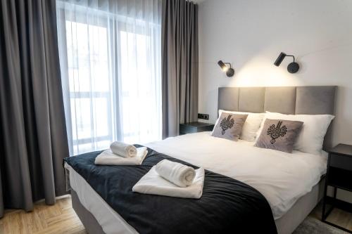 a bedroom with a large bed with towels on it at Stylchyn 90 Apartamenty nad Jeziorem Czorsztyńskim in Kluszkowce