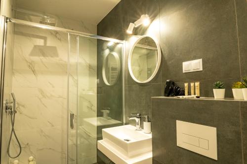 a bathroom with a sink and a shower at Stylchyn 90 Apartamenty nad Jeziorem Czorsztyńskim in Kluszkowce