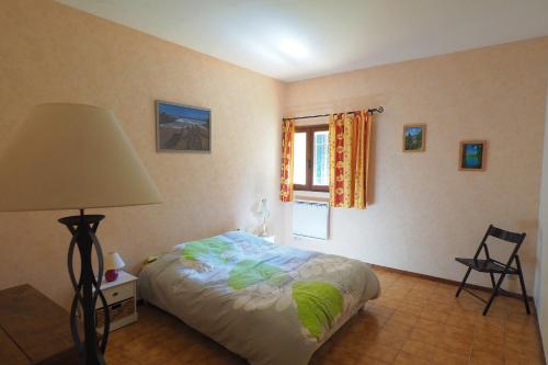Boucoiran-et-NozièresにあるLe gite de Modestineのベッドルーム1室(ベッド1台、ランプ、窓付)